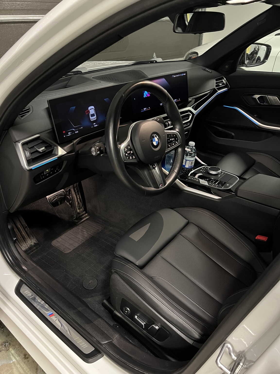 Detailed BMW interior with illuminated blue ambient lighting and clean driver area.