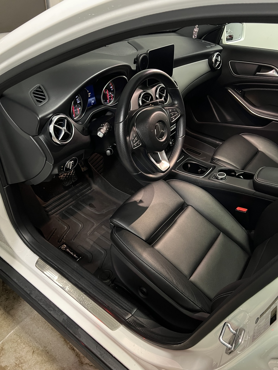 Detailed Mercedes interior with clean leather seat, dashboard, and floor area.